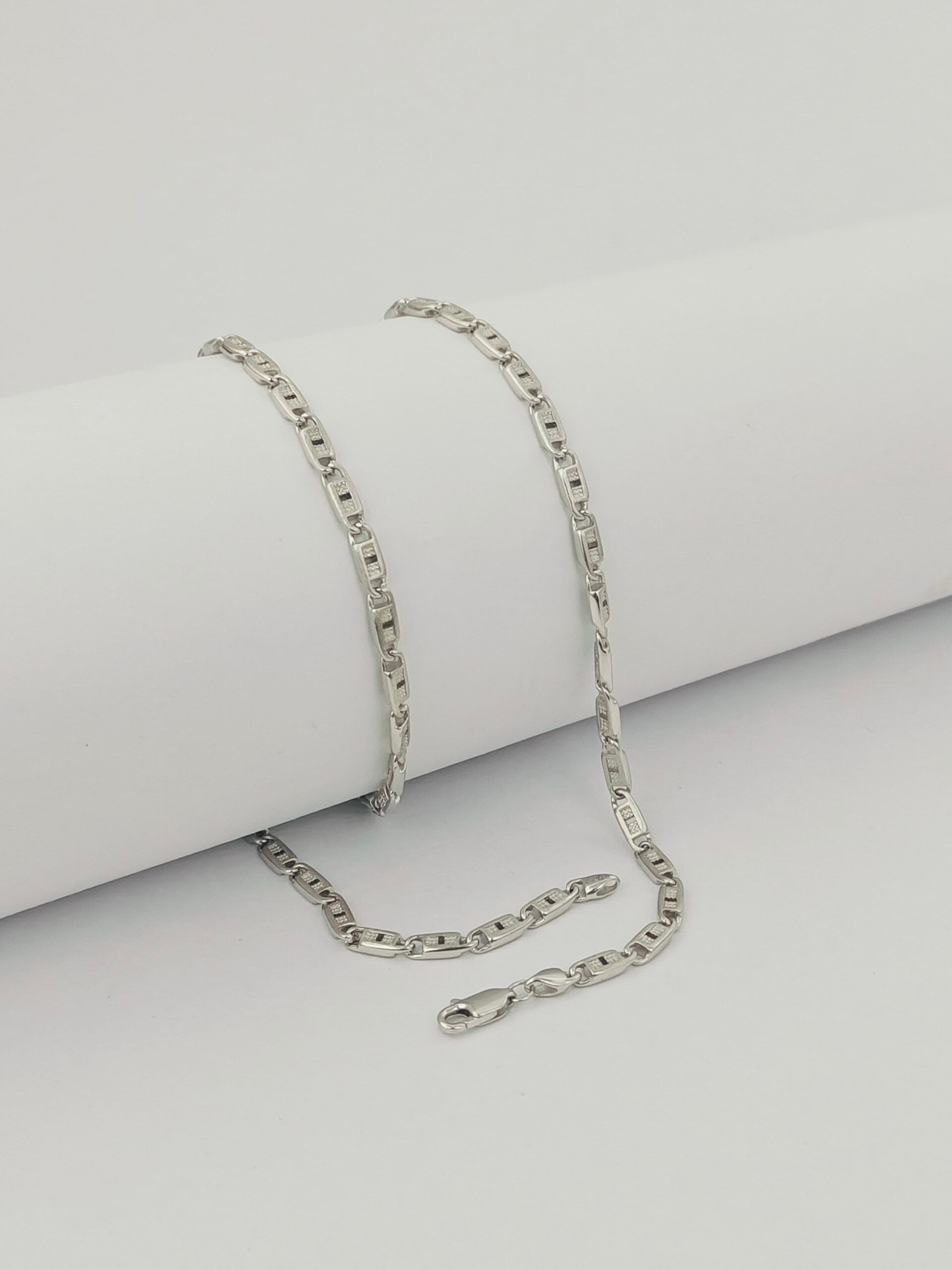 Silver chain necklace on a light gray background